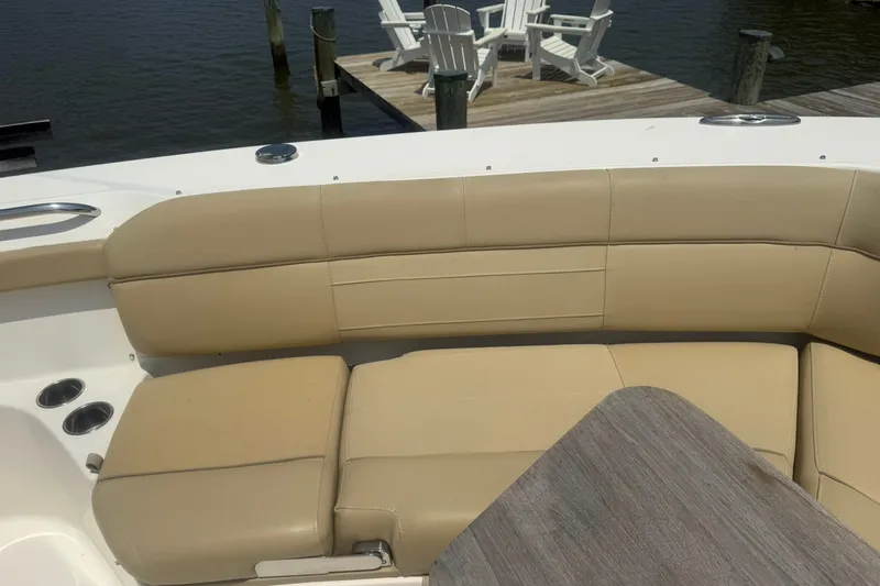 Slide: The Image of Beige seating on 2017 Pursuit S 408 Sport boat, dockside view with wooden chairs. - 38