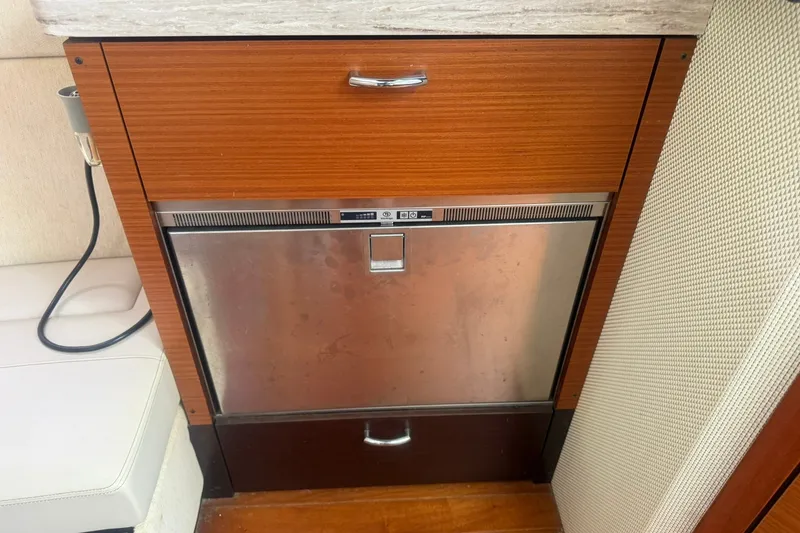 Slide: The Image of Wooden cabinet with stainless steel fridge on 2017 Pursuit S 408 Sport boat. - 48
