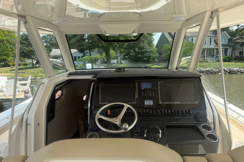 Slide: The Image of 2017 Pursuit S 408 Sport boat cockpit with advanced navigation controls and scenic waterfront view. - 22