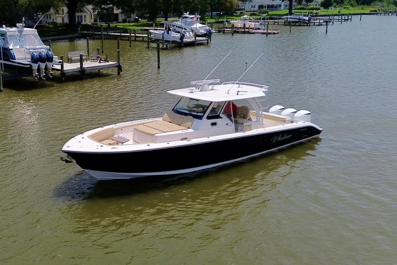 Slide: The Image of 2017 Pursuit S 408 Sport boat cruising on a calm river near docks. - 14