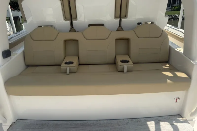 Slide: The Image of 2017 Pursuit S 408 Sport boat seating with beige cushions and cup holders. - 31