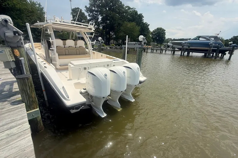 Slide: The Image of 2017 Pursuit S 408 Sport boat docked with triple Yamaha outboard engines. - 59