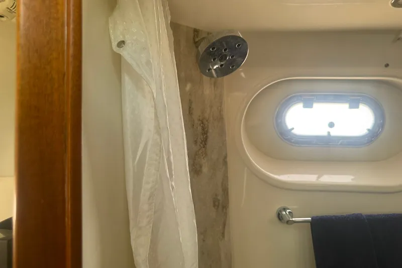 Slide: The Image of Shower area in 2017 Pursuit S 408 Sport boat with porthole and curtain. - 47