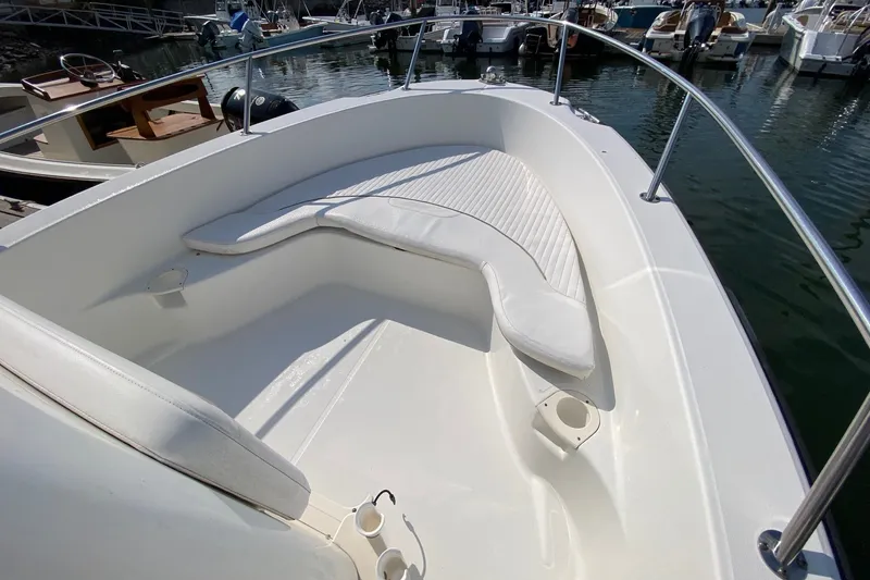 Slide: The Image of 2010 Boston Whaler 190 Outrage boat interior with cushioned seating and railings. - 18