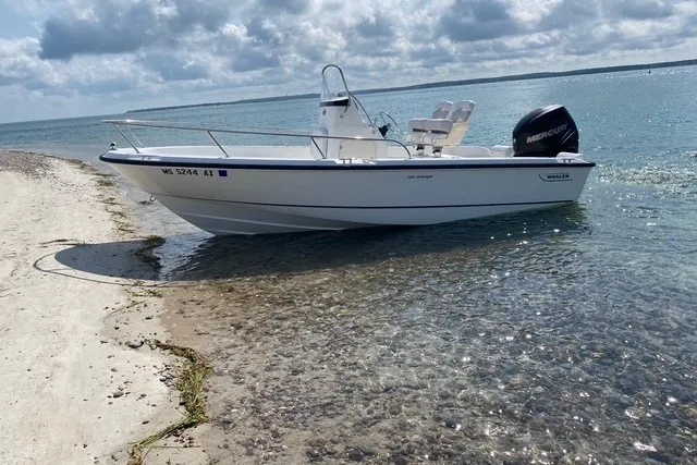 Slide: The Image of 2010 Boston Whaler 190 Outrage boat on a sandy beach with clear water. - 3