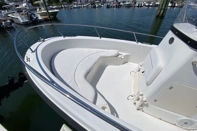 Slide: The Image of 2010 Boston Whaler 190 Outrage boat with spacious seating, docked in a marina. - 7