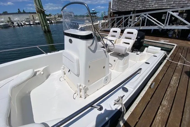 Slide: The Image of 2010 Boston Whaler 190 Outrage boat docked at marina under clear blue sky. - 5