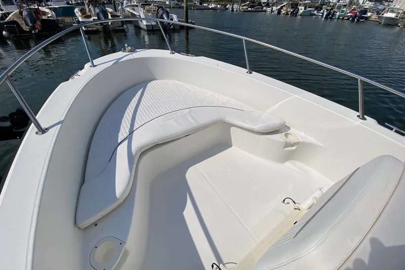 Slide: The Image of 2010 Boston Whaler 190 Outrage boat interior with white seating, docked at marina. - 17