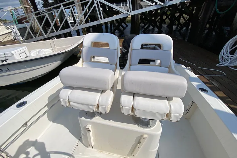 Slide: The Image of 2010 Boston Whaler 190 Outrage boat interior with dual white cushioned seats. - 14