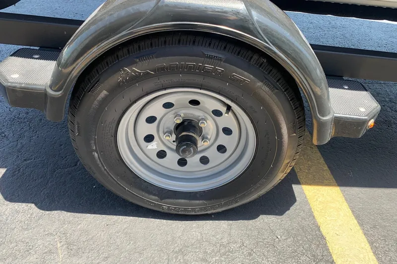 Slide: The Image of Trailer wheel of 2024 Alumacraft Classic 165 SC on asphalt parking lot. - 12
