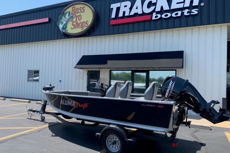 The Image of 2024 Alumacraft Classic 165 SC boat outside Bass Pro Shops and Tracker Boats store. - 1