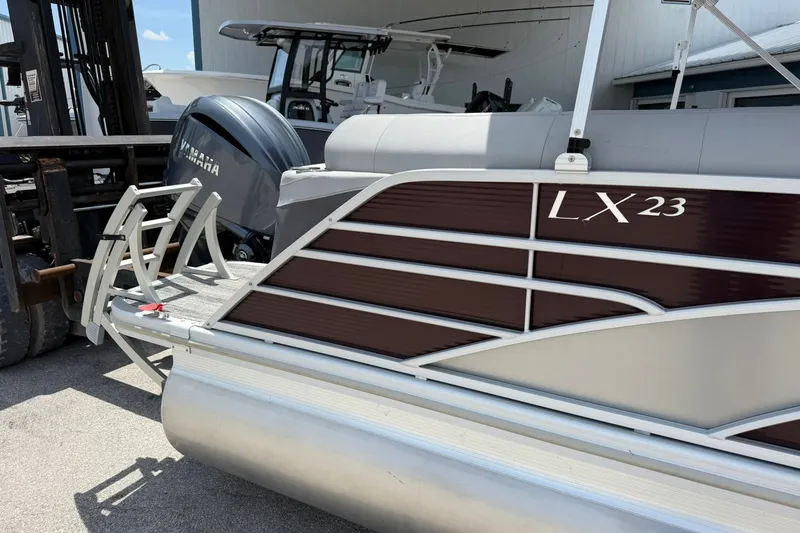 Slide: The Image of 2023 Bennington 23 LXFB pontoon boat with Yamaha engine, docked outdoors. - 1