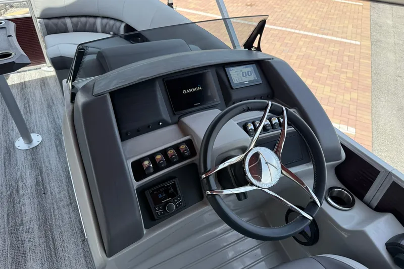 Slide: The Image of 2023 Bennington 23 LXFB boat dashboard with Garmin display and modern steering wheel. - 15