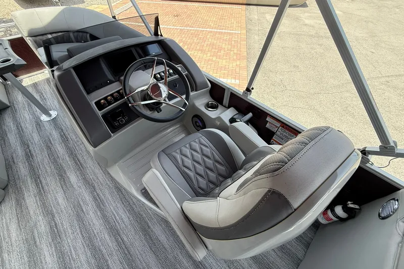 Slide: The Image of 2023 Bennington 23 LXFB boat interior with modern steering console and luxurious seating. - 14