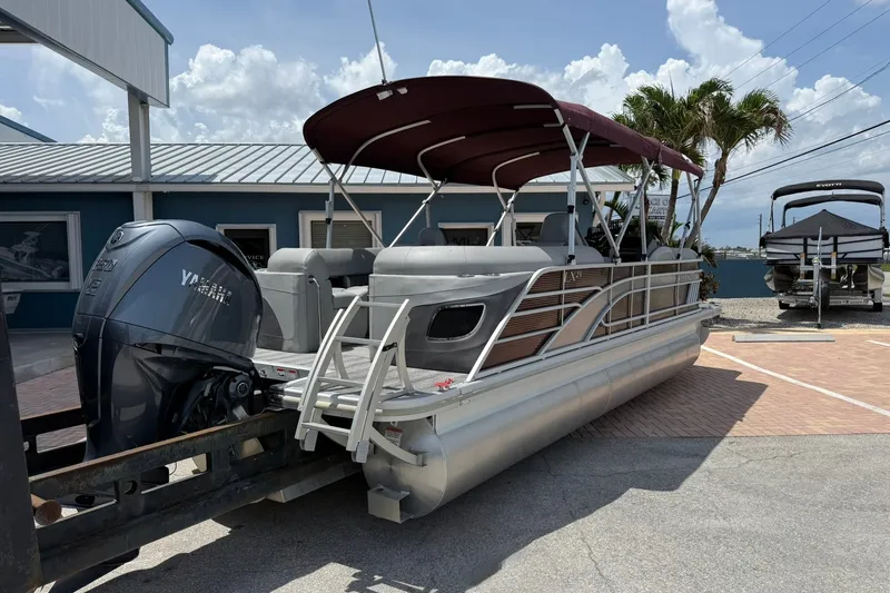 Slide: The Image of 2023 Bennington 23 LXFB pontoon boat with Yamaha engine, parked outdoors. - 3