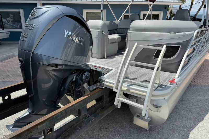 Slide: The Image of 2023 Bennington 23 LXFB pontoon boat with Yamaha outboard motor and boarding ladder. - 2