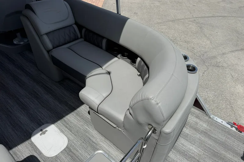 Slide: The Image of 2023 Bennington 23 LXFB boat interior with gray cushioned seating and cup holders. - 10