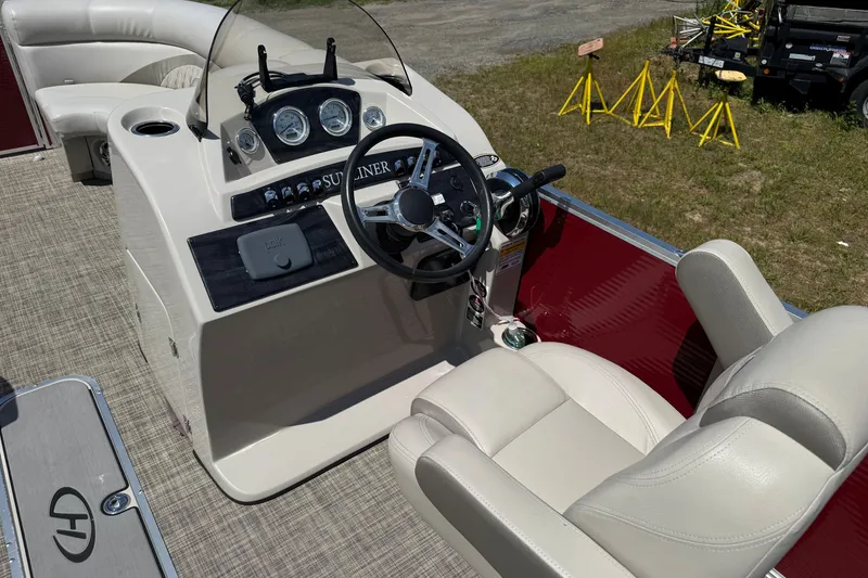 Slide: The Image of 2018 Harris Sunliner 220 boat interior with steering console and beige seating. - 13