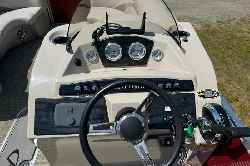 Slide: The Image of 2018 Harris Sunliner 220 boat dashboard with steering wheel and control panel. - 12
