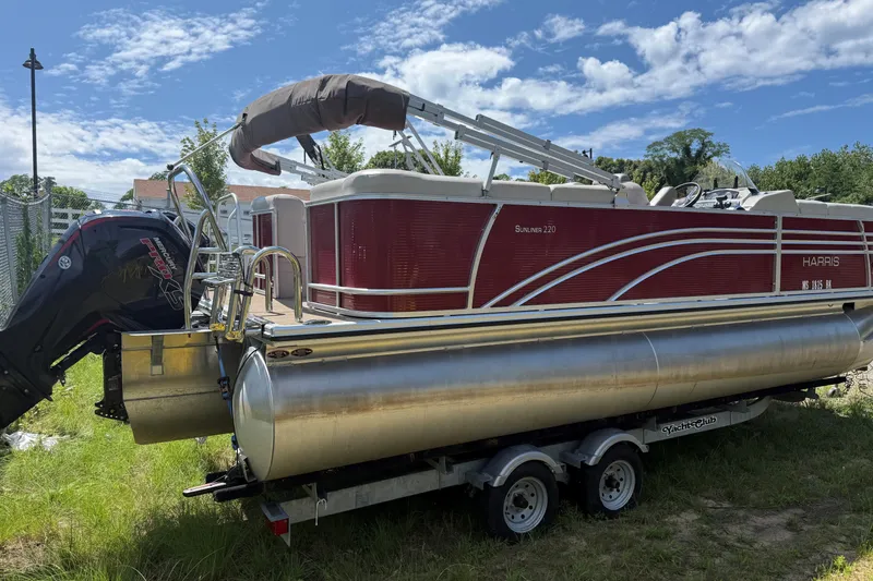 Slide: The Image of 2018 Harris Sunliner 220 pontoon boat on trailer, parked on grass under blue sky. - 3