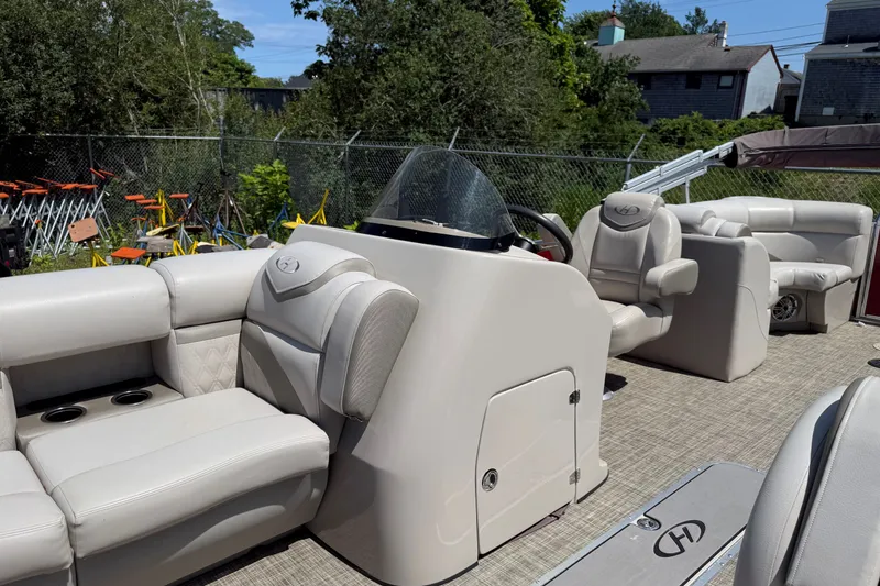 Slide: The Image of 2018 Harris Sunliner 220 pontoon boat interior with plush seating and steering console. - 10
