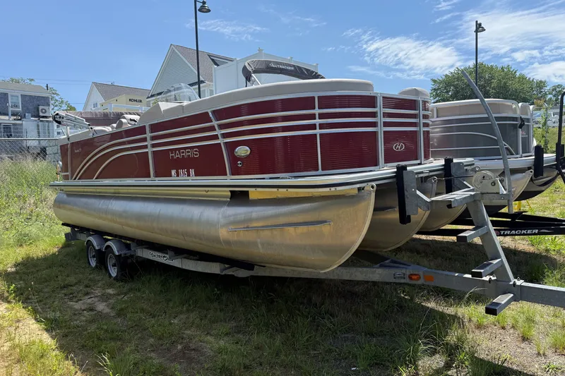 Slide: The Image of 2018 Harris Sunliner 220 pontoon boat on trailer, parked outdoors under clear sky. - 1