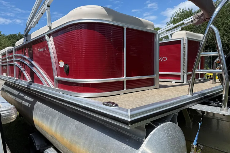 Slide: The Image of 2018 Harris Sunliner 220 pontoon boat with red exterior and aluminum railing. - 4
