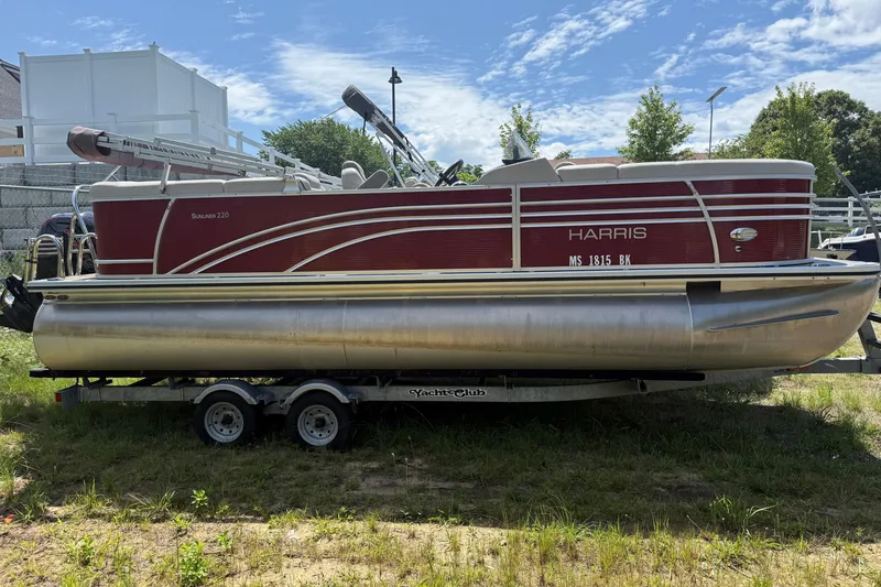 The Image of 2018 Harris Sunliner 220 pontoon boat on trailer, parked outdoors under a clear sky. - 0