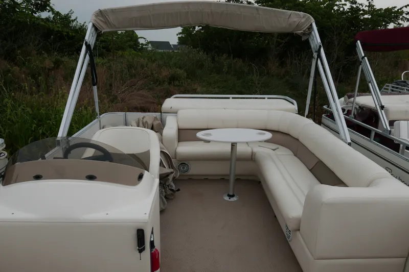 Slide: The Image of 2006 Crest 22 Super Sport pontoon boat with beige seating and canopy, docked near greenery. - 8
