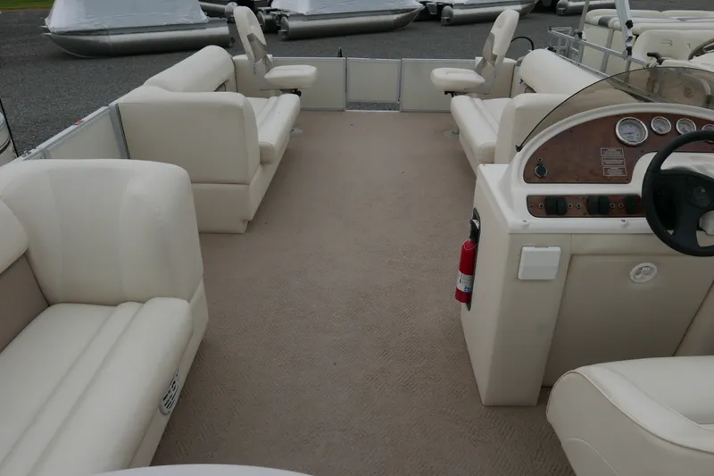 Slide: The Image of Interior of a 2006 Crest 22 Super Sport pontoon boat with beige seating and dashboard. - 12