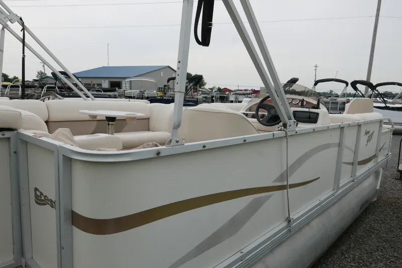 Slide: The Image of 2006 Crest 22 Super Sport pontoon boat with beige seating and steering console. - 3