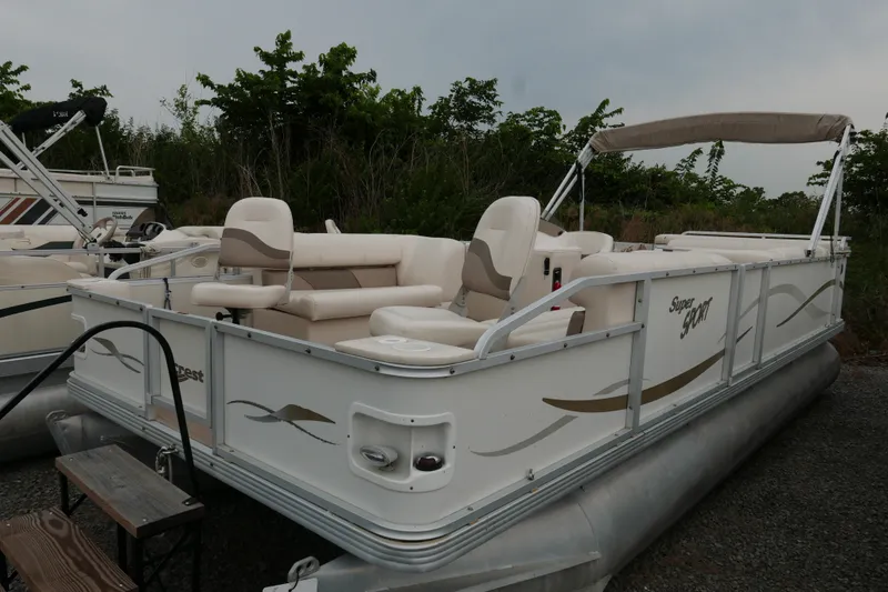The Image of 2006 Crest 22 Super Sport pontoon boat with beige seating, parked outdoors. - 0