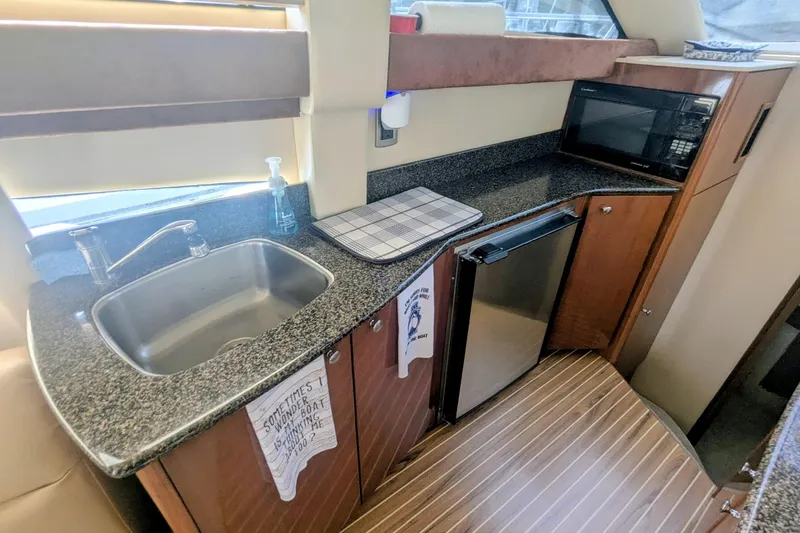 Slide: The Image of Compact kitchen area in a 2006 Meridian 341 Sedan yacht with sink, fridge, and microwave. - 25