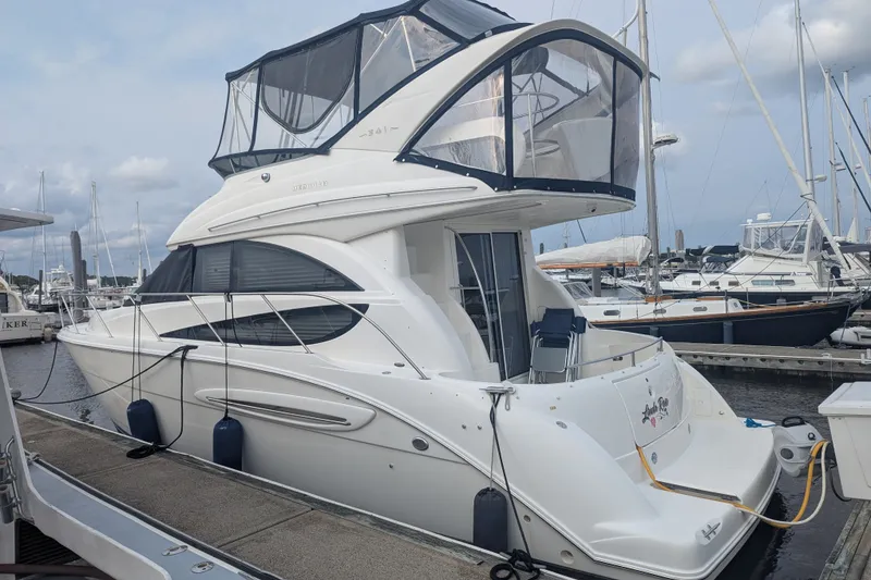 Slide: The Image of 2006 Meridian 341 Sedan yacht docked at marina, featuring sleek design and upper deck enclosure. - 7