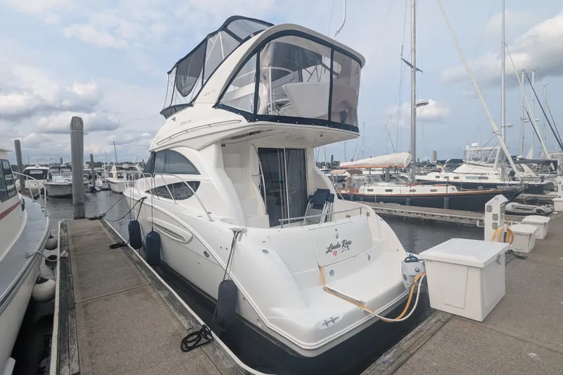 Slide: The Image of 2006 Meridian 341 Sedan yacht docked at a marina, showcasing sleek design and spacious upper deck. - 6