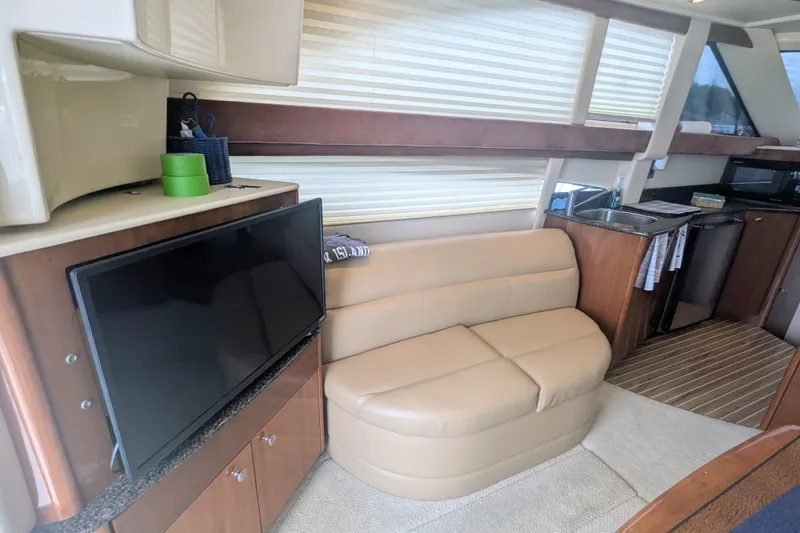 Slide: The Image of Interior of 2006 Meridian 341 Sedan yacht with TV, beige sofa, and kitchenette. - 24
