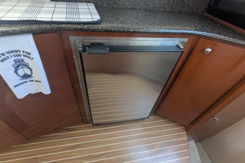 Slide: The Image of Compact kitchen area in a 2006 Meridian 341 Sedan yacht with stainless steel fridge. - 28