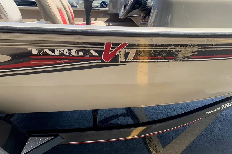 Slide: The Image of 2005 Tracker Targa 17 WT boat with worn decals and visible interior seating. - 13