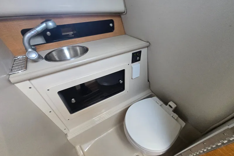 Slide: The Image of 2006 Robalo R265 Walkaround boat interior with sink and toilet in compact bathroom. - 5