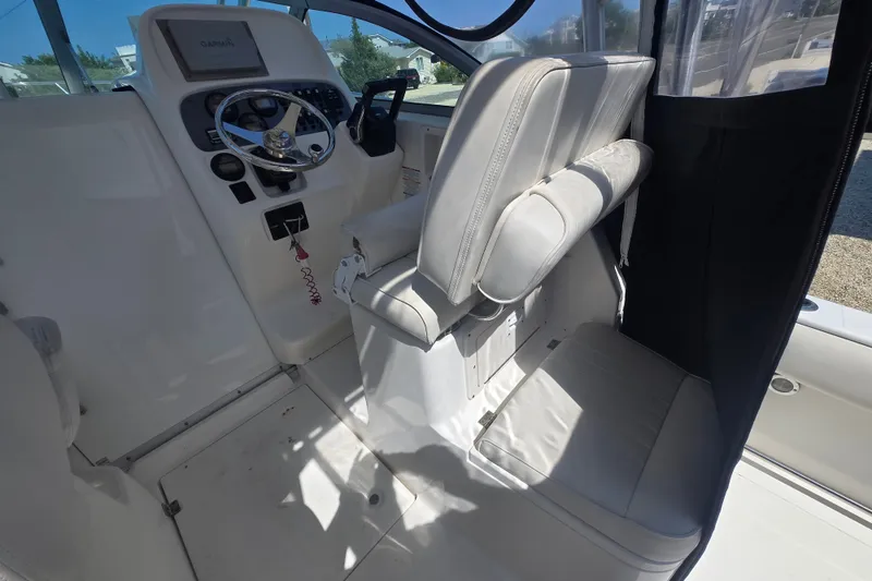 Slide: The Image of 2006 Robalo R265 Walkaround boat interior with steering wheel and seating area. - 10