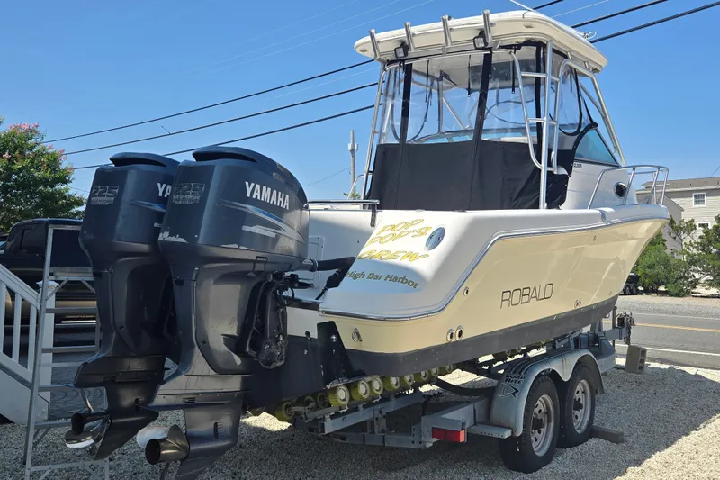 Slide: The Image of 2006 Robalo R265 Walkaround boat with twin Yamaha engines on a trailer. - 9