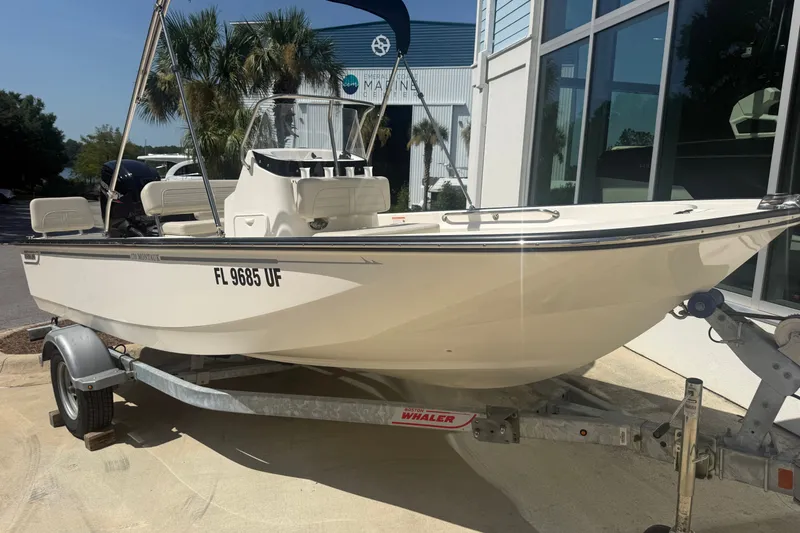 The Image of 2026 Boston Whaler 170 Montauk boat on trailer, parked outdoors near a building. - 1