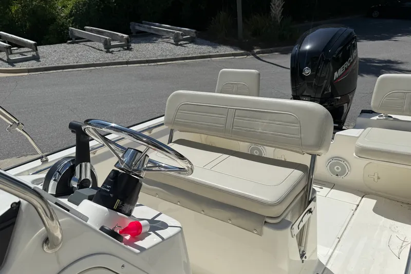 Slide: The Image of 2026 Boston Whaler 170 Montauk boat interior with steering wheel and Mercury engine. - 7