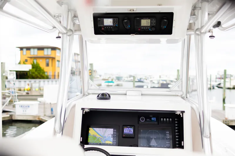 Slide: The Image of 2021 Onslow Bay 27 Offshore Edition boat dashboard with navigation and control systems at a marina. - 5
