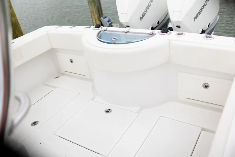 Slide: The Image of 2021 Onslow Bay 27 Offshore Edition boat interior with storage compartments and twin Mercury engines. - 8