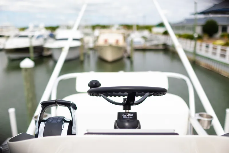 Slide: The Image of 2021 Onslow Bay 27 Offshore Edition boat helm at marina, showcasing steering wheel and controls. - 14