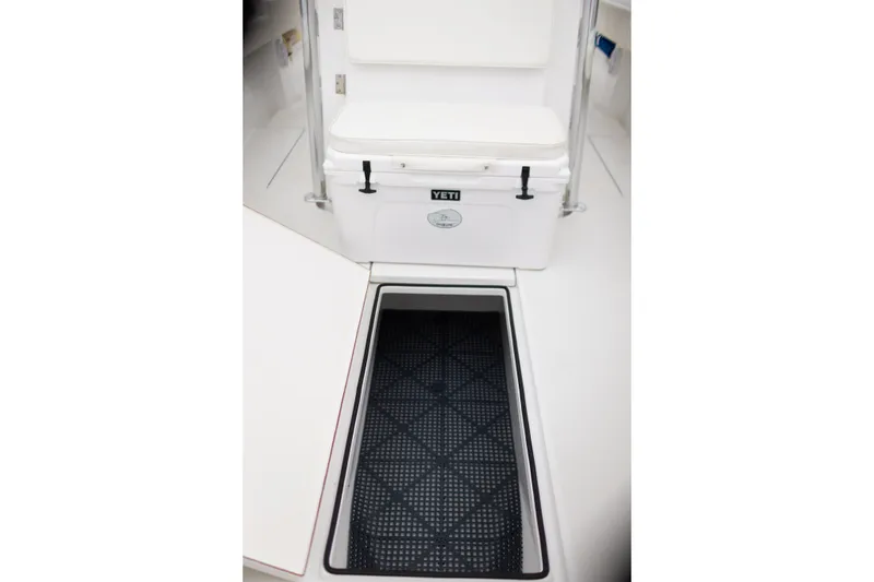 Slide: The Image of 2021 Onslow Bay 27 Offshore Edition boat interior with Yeti cooler and storage compartment. - 23