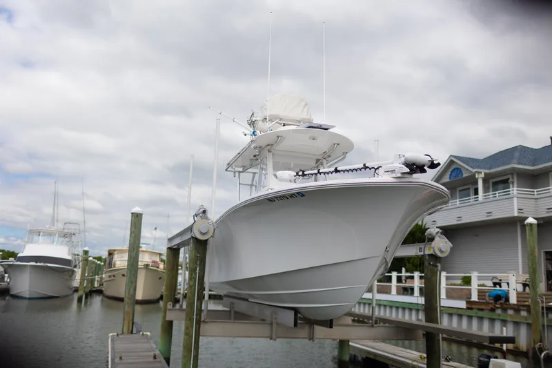 Slide: The Image of 2021 Onslow Bay 27 Offshore Edition boat docked at marina, cloudy sky background. - 35