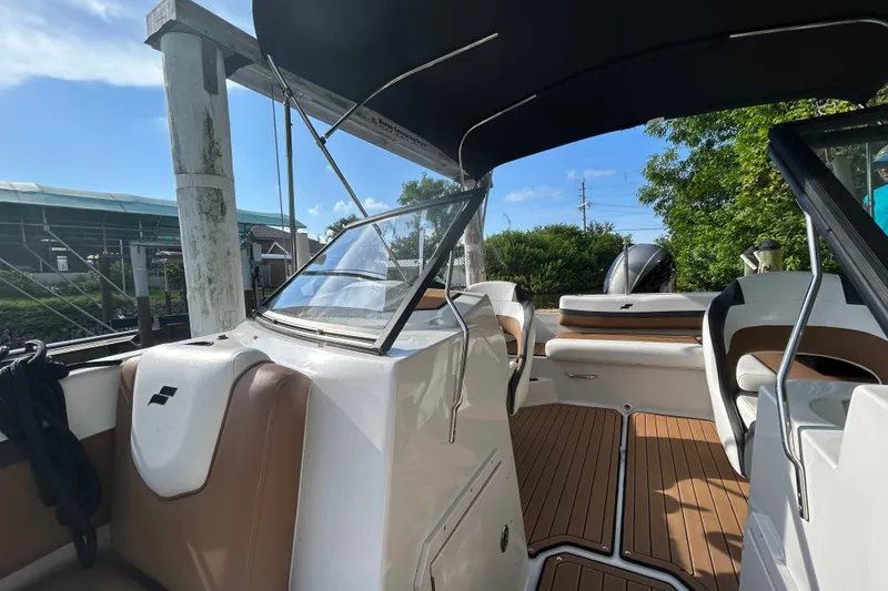 Slide: The Image of 2023 Starcraft SVX 191 OB boat interior with seating and canopy under blue sky. - 12