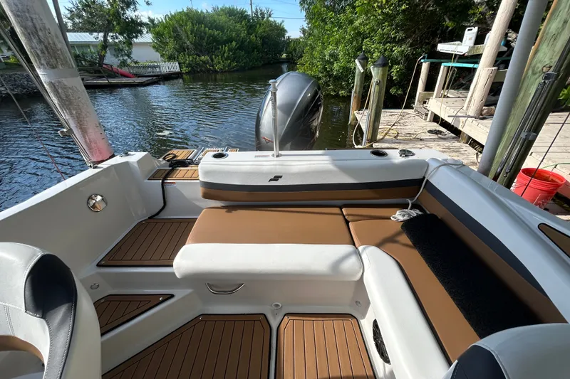 Slide: The Image of 2023 Starcraft SVX 191 OB boat interior with tan seating and wood accents by the water. - 18